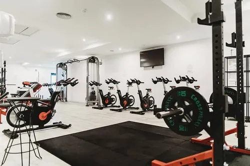 a room with exercise bikes and a black mat